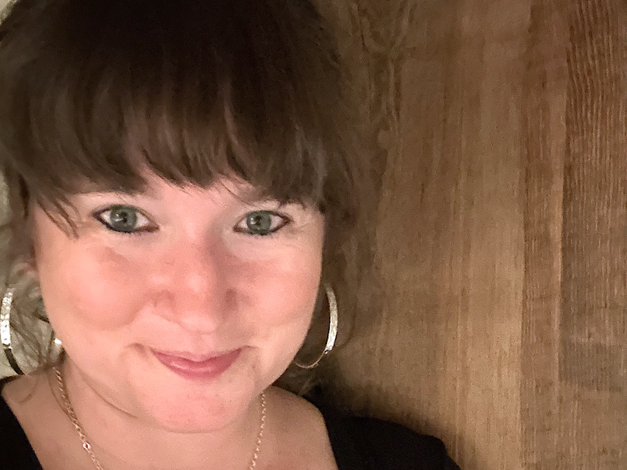 Julie Park smiling, wearing a distinctive silver pendant necklace.