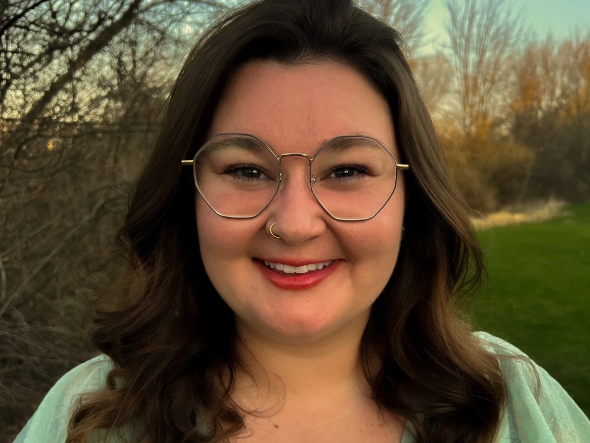 Sofia Bieniak, board member, is smiling in the picture and wearing geometric glasses.